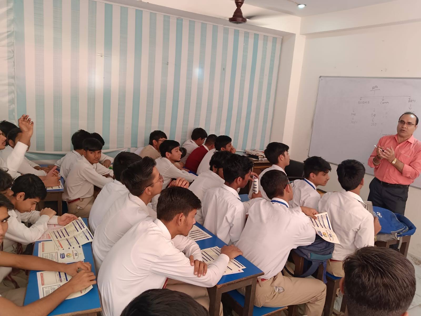 An instructor presenting a technical concept on a whiteboard to an attentive class of students, emphasizing interactive learning at OM Info Solutions.