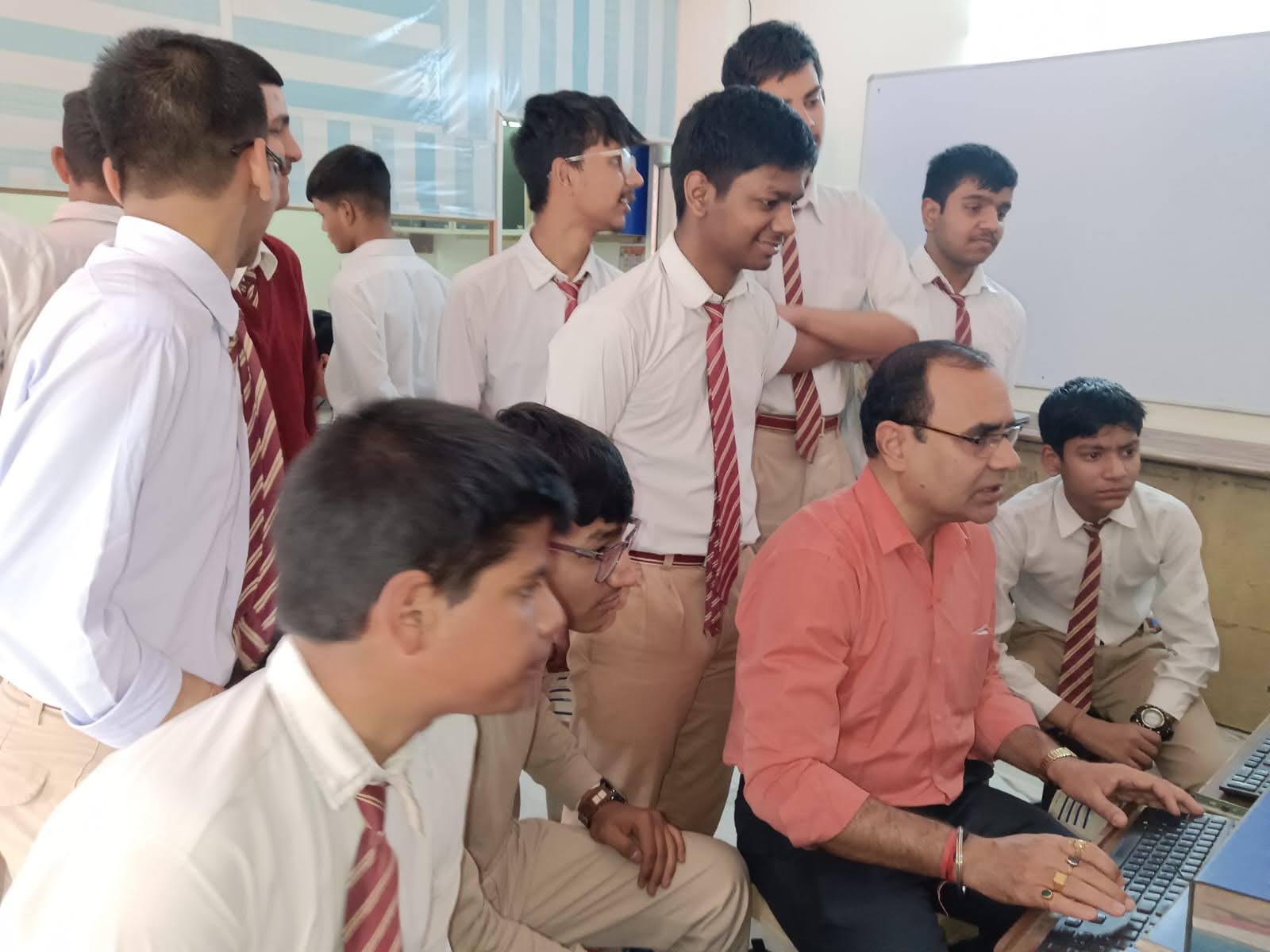 A group of students collaborating on a coding project at computers, showcasing teamwork and practical learning at OM Info Solutions.